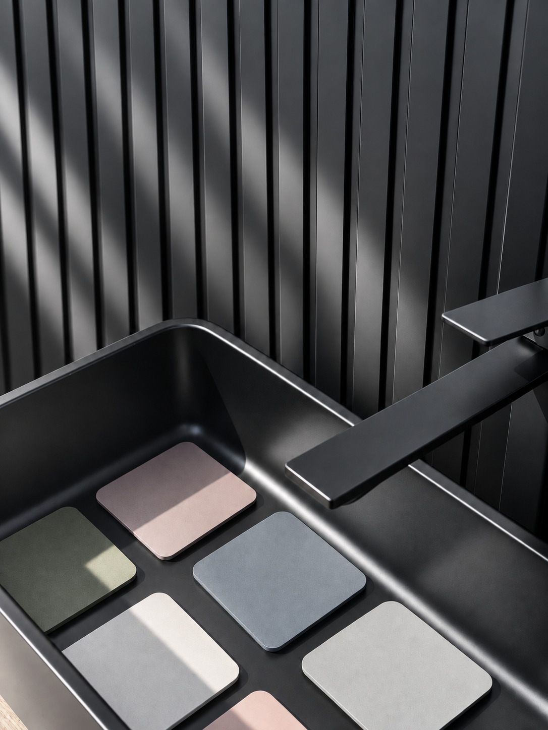 The basin in matt black, with colour samples for the bathroom finishes