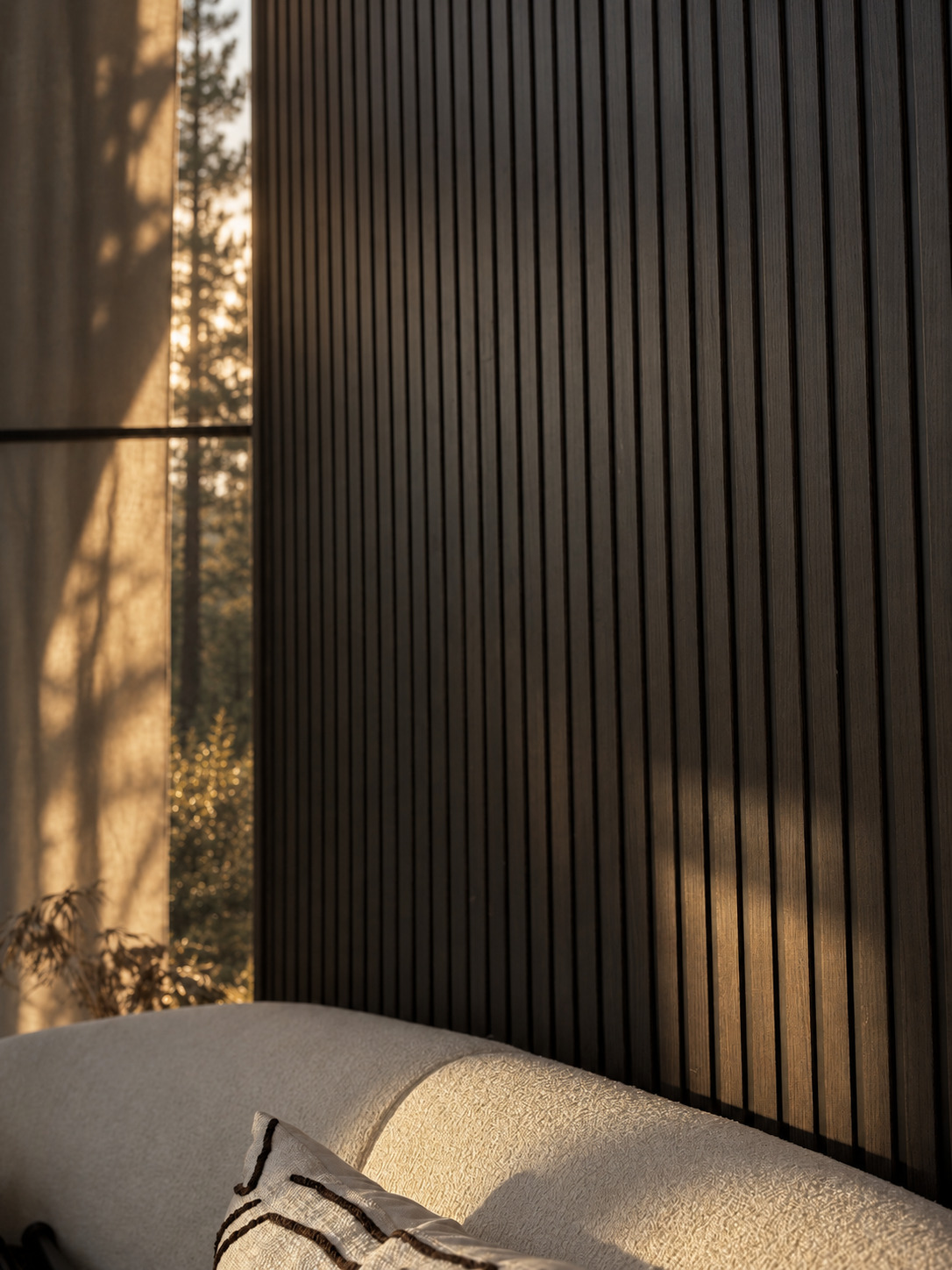 Evening light across the slatted wall and the bouclé sofa